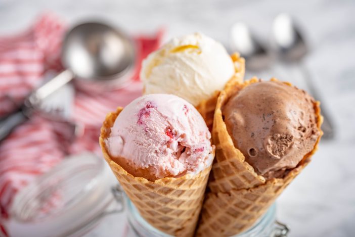 Waffle cones filled with strawberry, chocolate, and vanilla ice cream.