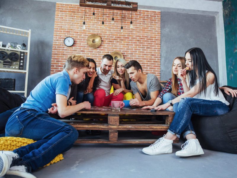 Group of friends gathered around a table playing a game.