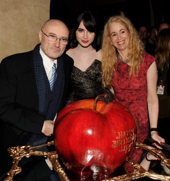LOS ANGELES, CA - MARCH 17: (L-R) Musician Phil Collins, his daughter actress Lily Collins and her mom Jill Tavelman pose with Lily's birthday cake at the after party for the premiere of Relativity Media's "Mirror Mirror" at the Hollywood Roosevelt Hotel on March 17, 2012 in Los Angeles, California.