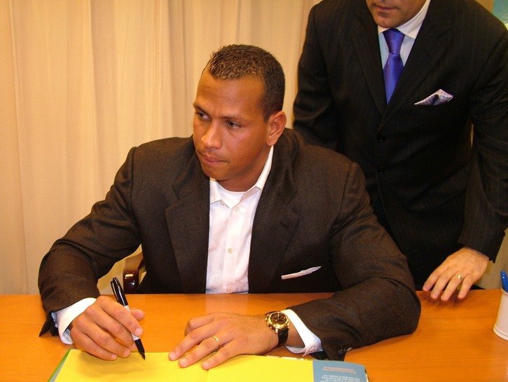 Alex Rodriguez wearing a brown suit at a book signing.