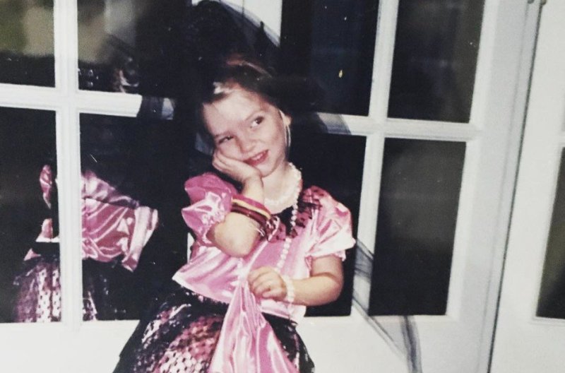Anya Taylor-Joy in a pink satin dress as a child.