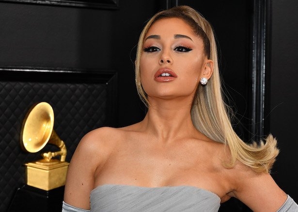 Ariana Grande in grey dress on black background at the Grammys