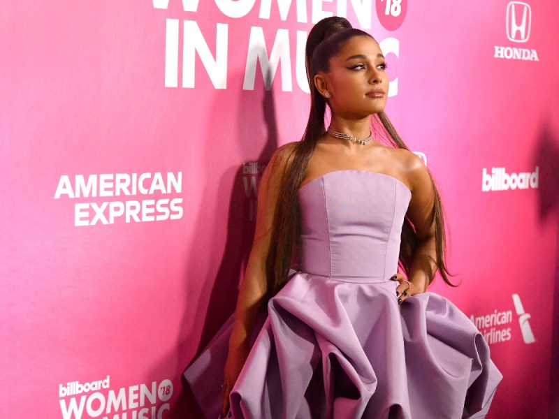 Ariana Grande poses in lavender strapless gown against pink backdrop