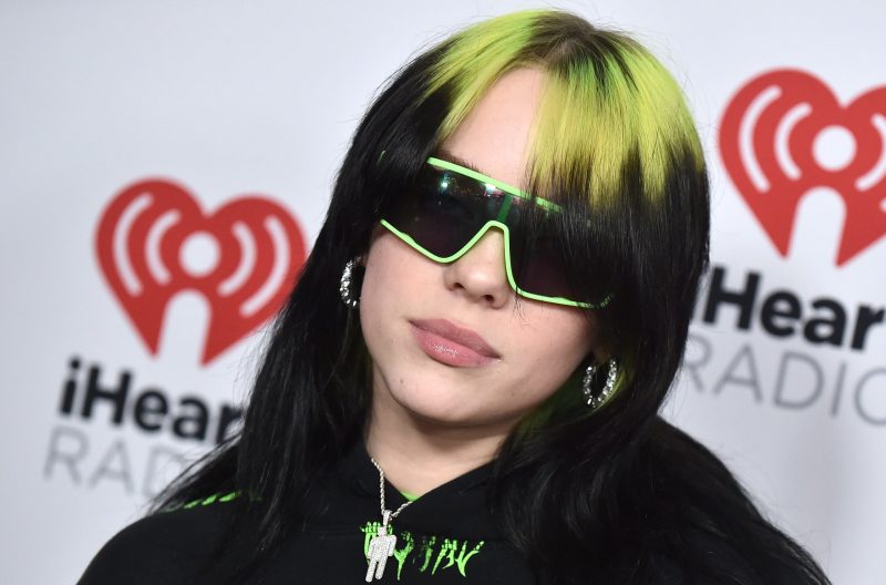 Billie Eilish with black and green hair with green sunglasses on