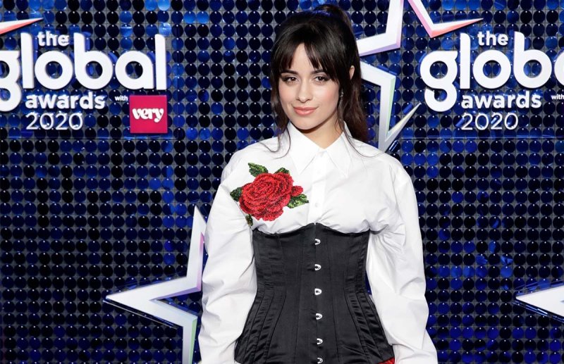 Camila Cabello in a white and black dress with a large rose embroidered on it