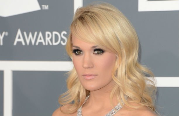 Carrie Underwood wearing a silver dress on the red carpet