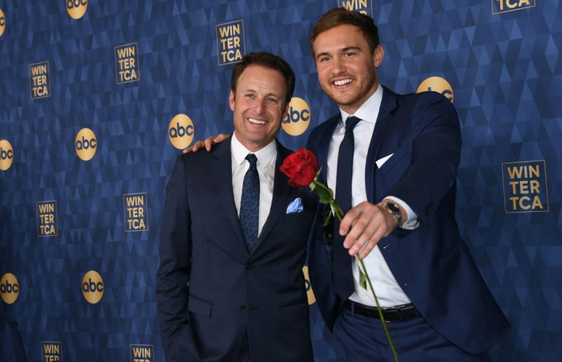 Chris Harrison and Peter Weber wearing dark navy suits on the red carpet
