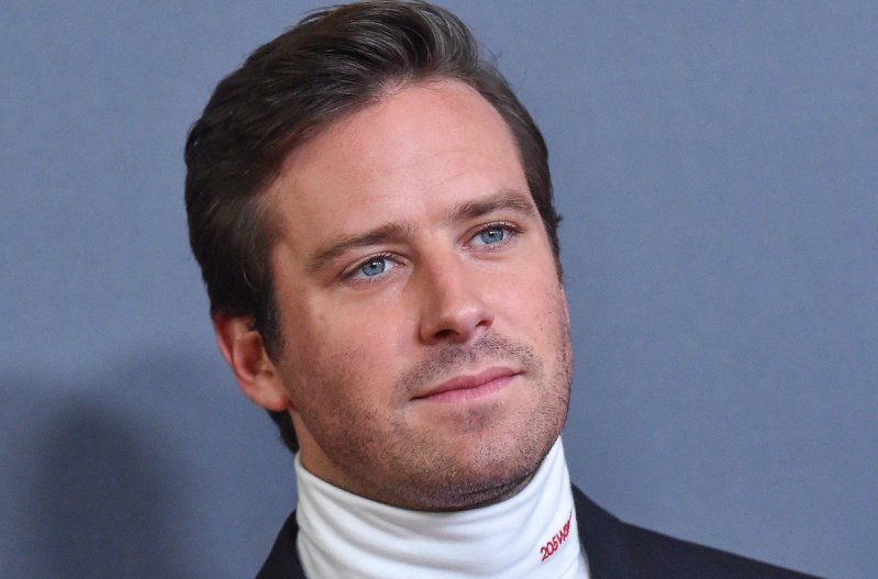 Close up of Armie Hammer in a turtleneck and jacket