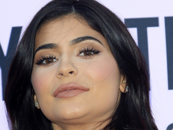 Close up photo of Kylie Jenner, in an orange dress, at the Pretty Little Things launch event in 2016
