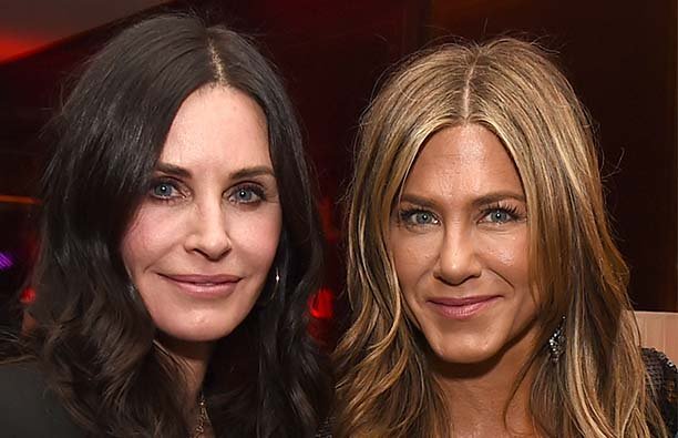 Courteney Cox and Jennifer Aniston posing together at a party
