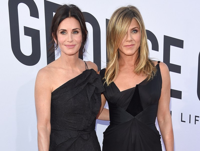 Courteney Cox on the left and Jennifer Aniston on the right, together in black dress at a red carpet event.