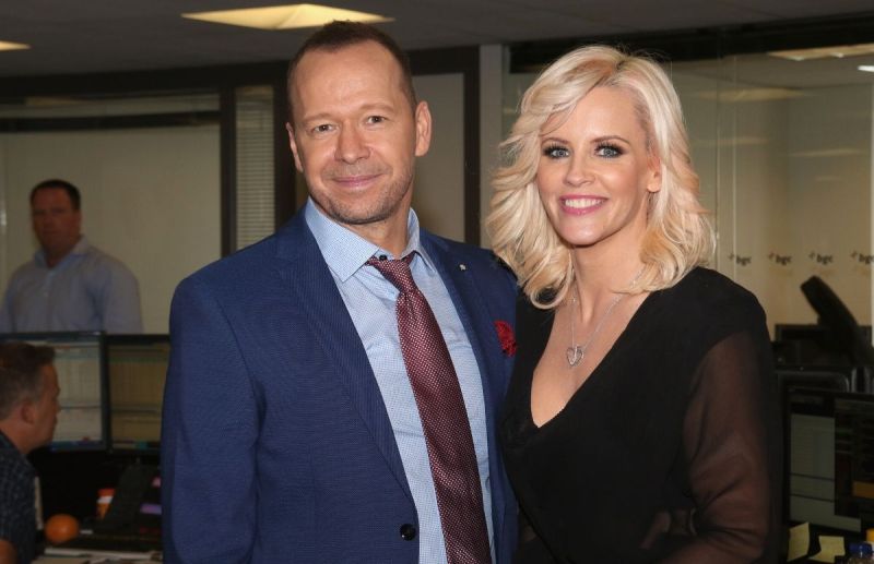Donnie Wahlberg wearing a blue suit standing with Jenny McCarthy, who's wearing a black dress, at a