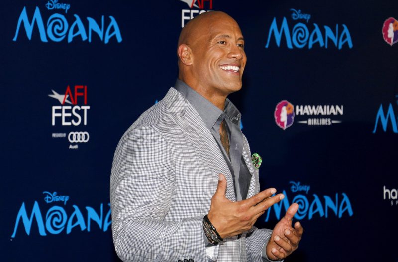 Dwayne Johnson wearing a suit and gray shirt to the premiere of Disney's Moana