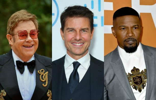 Elton John wearing a dark suit with gold embroidery on the red carpet. Tom Cruise wearing a dark sui