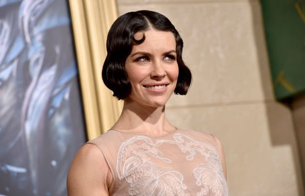 Evangeline Lilly wearing a nude colored, lace embossed dress on the red carpet.