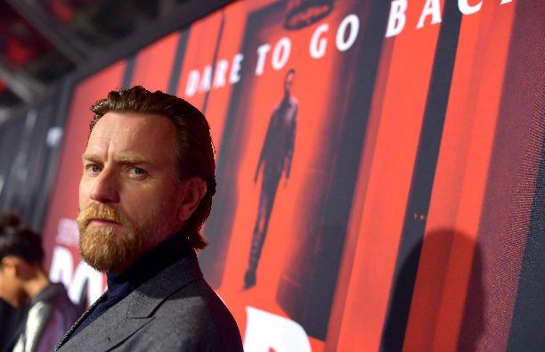 Ewan McGregor in a dark gray suit on the red carpet.