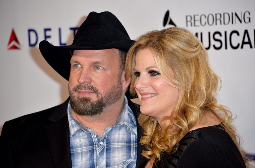 Garth Brooks wearing a black jacket and cowboy hat and Trisha Yearwood in a black dress.