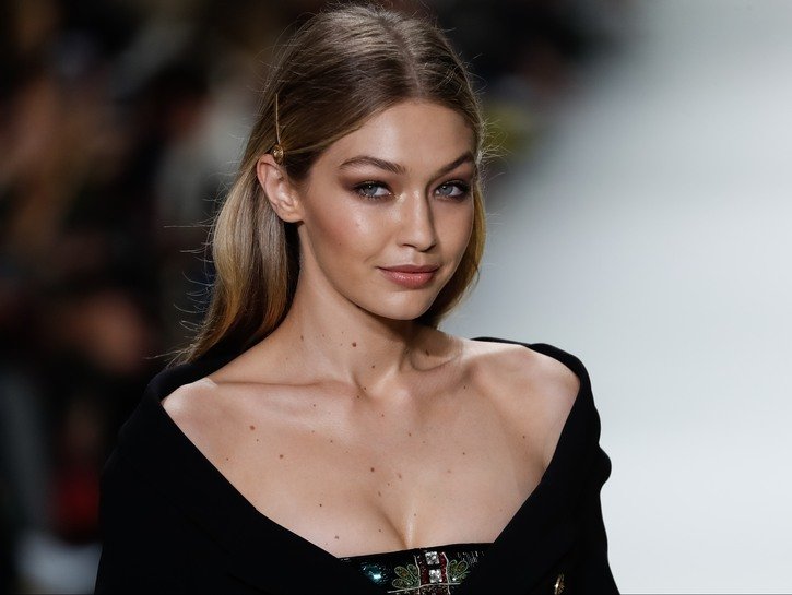 Gigi Hadid wearing a black dress while walking the catwalk during a Versace fashion show in Milan