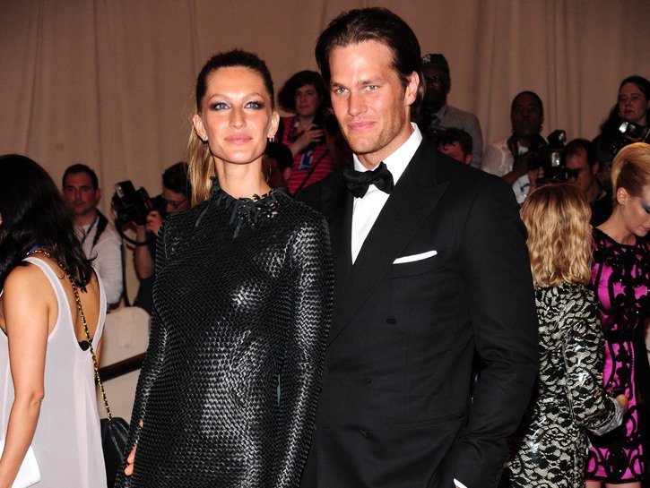 Gisele Bundchen, in a black dress, standing with Tom Brady, wearing a black tux, at the Met Gala