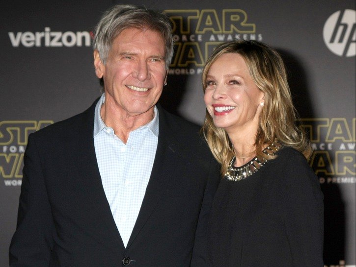 Harrison Ford wearing a black blazer stands with Calista Flockhart at a Star Wars premiere