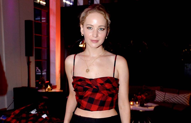 Jennifer Lawrence in a red and black crop top smiling for the camera