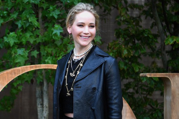 Jennifer Lawrence smiling in a black leather jacket with a black top