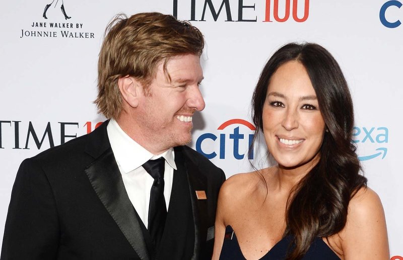 Joanna Gaines and Chip Gaines smiling on a red carpet.