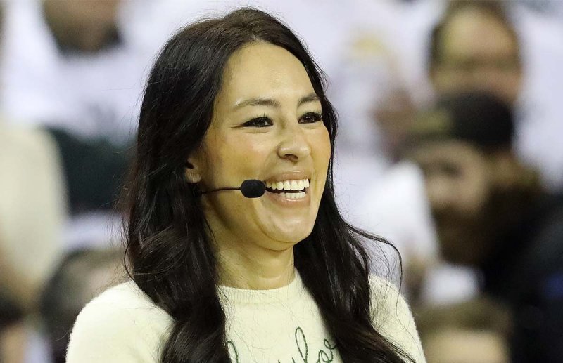 Joanna Gaines laughing and wearing a microphone headset.