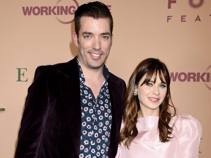 Jonathon Scott on the left in a maroon jacket, Zooey Deschanel on the right in a pink dress.