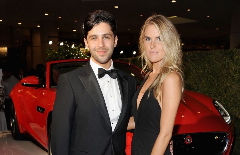 Josh Peck wearing a black tux standing with wife Paige O'Brien, who's wearing a black dress at the 2