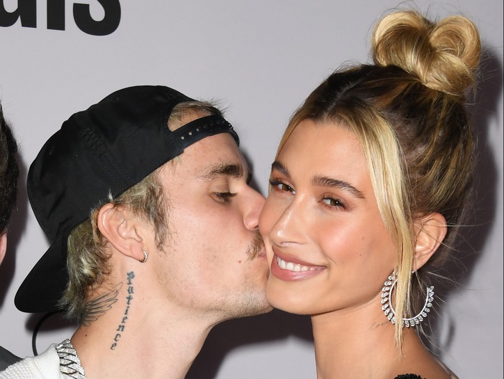 Justin Bieber on the left, kissing Hailey Baldwin on the cheek.
