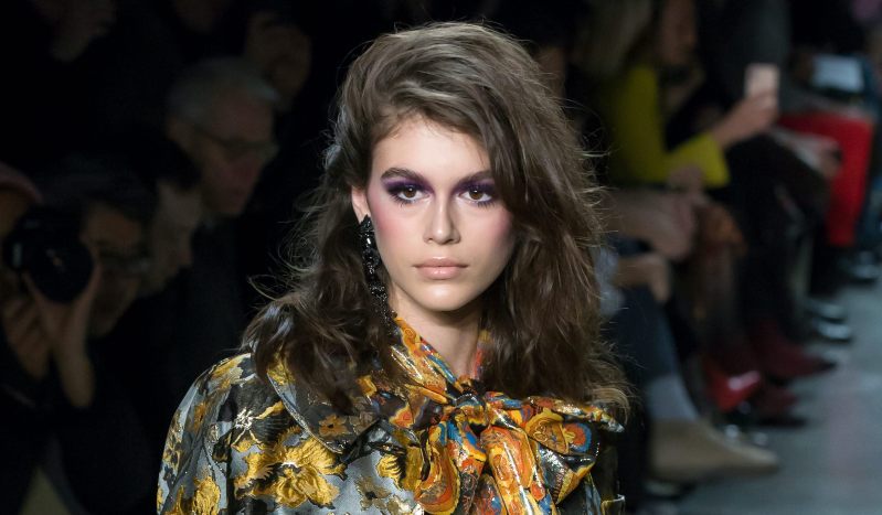 Kaia Gerber walking down the runway in a floral outfit