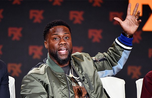 Kevin Hart waving to the crown at a live radio appearance.