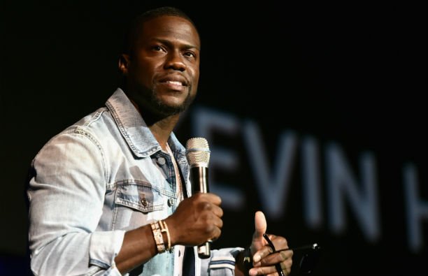 Kevin Hart wearing a denim jacket on stage at CinemaCon 2016