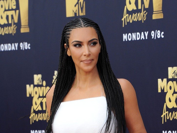 Kim Kardashian with her hair in braids and wearing a white, strapless dress MTV Movie and TV Awards