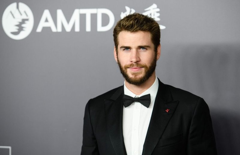 Liam Hemsworth wearing a black tux on the red carpet