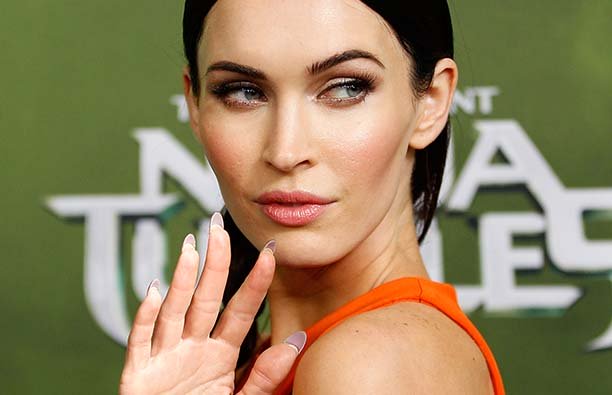 Megan Fox holdling up her hand and waving