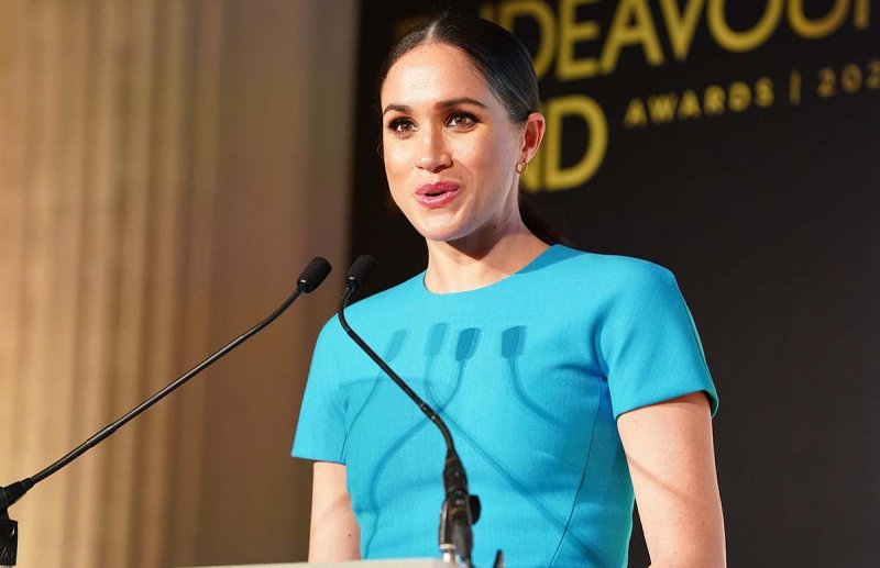 Meghan Markle in a blue dress standing at a podium