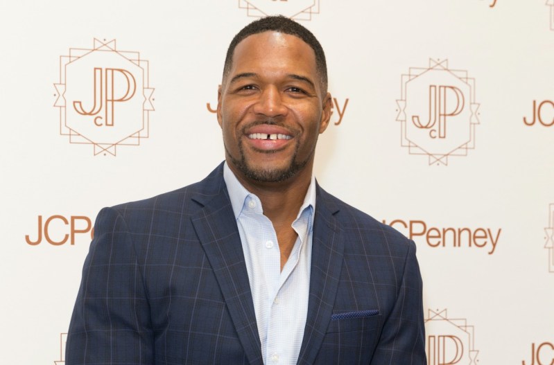 Michael Strahan smiling in a blue suit