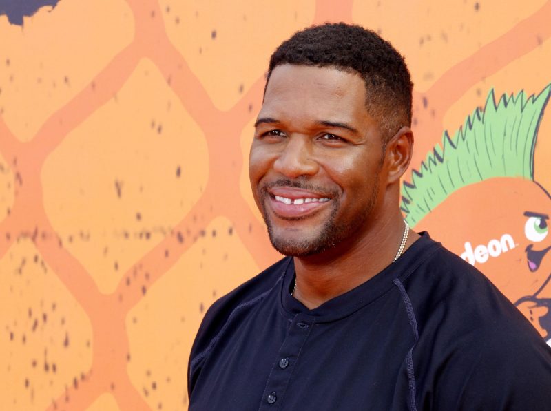 Michael Strahan wearing a dark shirt on the red carpet of the Nickelodeon Kid's Choice Awards 2016