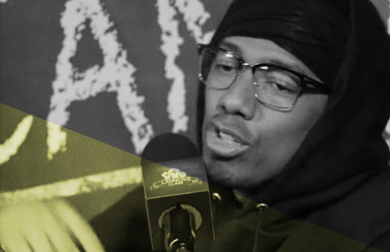 Nick Cannon wearing glasses and a hoodie while hosting his podcast