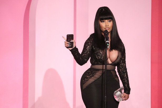 Nicki Minaj in a black dress holding her phone and Gamechanger Award at Billboard Women in Music 201
