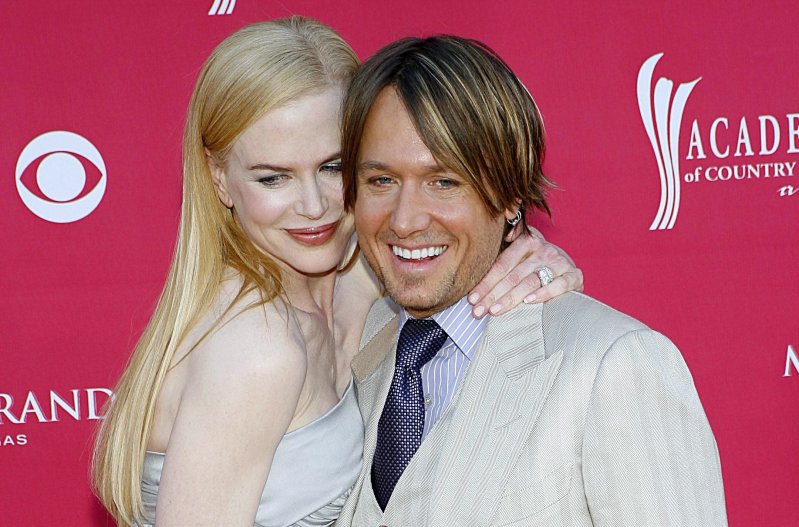 Nicole Kidman and Keith Urban, in silver and beige respectively, cuddle close together
