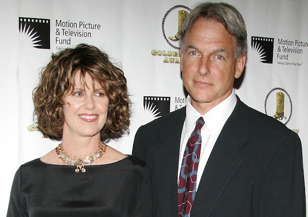 Pam Dawber in a black top next to Mark Harmon in a black suit, white shirt, patterned red tie