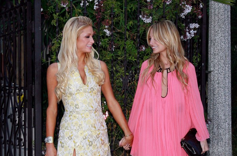Paris Hilton and Nicole Richie holding hands and smiling at one another