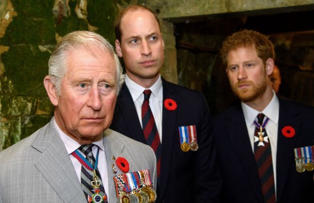 Prince Charles in a light gray suit, Prince William in a black suit, and Prince Harry in a black sui
