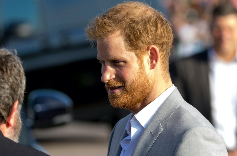 Prince Harry smiling in a grey suit