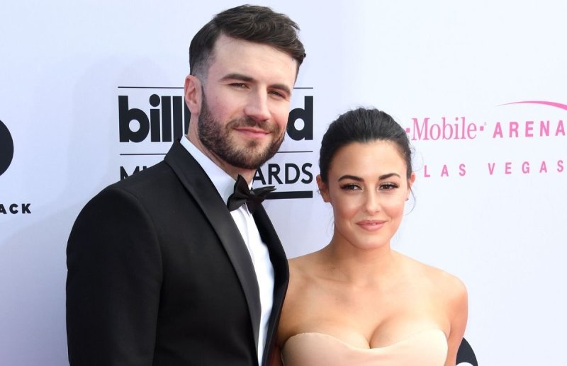 Sam Hunt wearing a black tux standing with his wife, Hannah Lee Fowler, who's wearing a pale pink dr