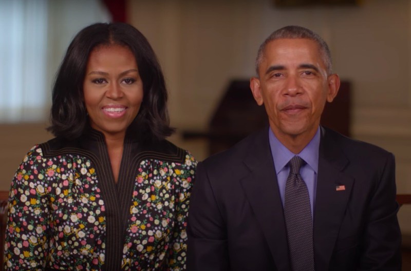 Screenshot from an Obama Foundation video with Michelle Obama sitting next to Barack Obama in a suit