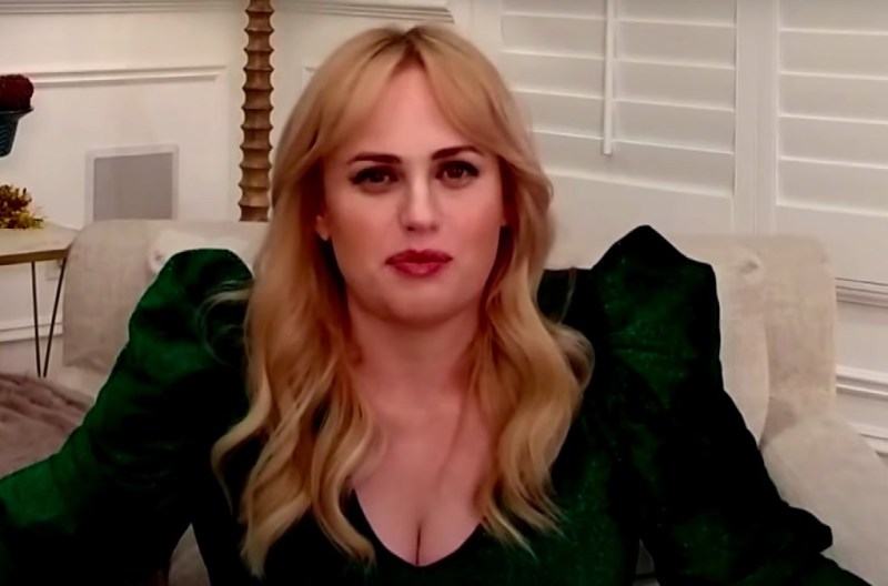 Screenshot from the Drew Barrymore show of Rebel Wilson sitting in a chair at home in a green dress
